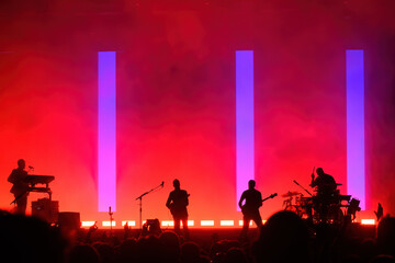 Silhouettes of an unregnizable music band during a concert
