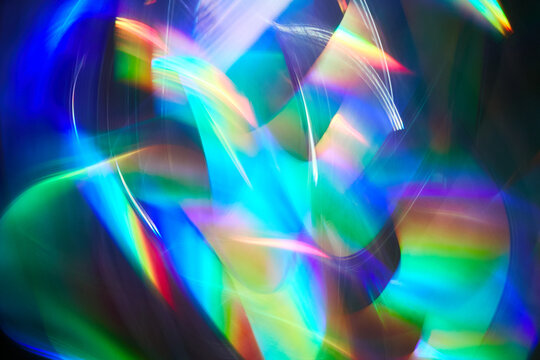 Blurred bright rainbow light. Lens or prism dynamic flare. Draving shiny spots. Dark background. Illuminated burst of multicolor light.