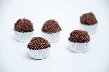 Assorted brigadeiros, traditional Brazilian sweets, beautifully arranged on a clean white background