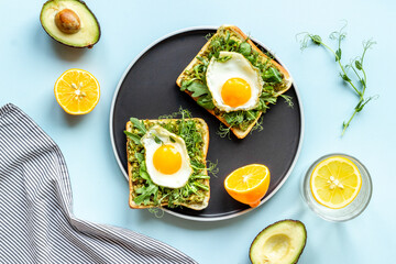 Open sandwich with avocado spinach cream and eggs. Top view