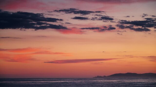 Red orange sky after sunset over sea. Nature, coastal landscape. Capi Corb, Mediterranean coast of Spain.
