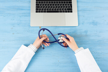 Top view of doctor hands typing at laptop