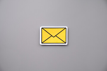 Yellow message sign or envelope against grey background