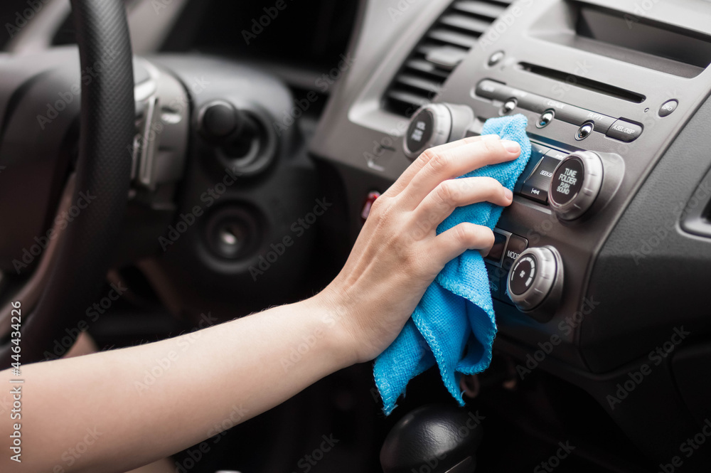 Wall mural the hand wipes the interior of the car with a rag. close up