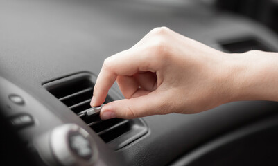The hand adjusts the air conditioner in the car. Close up