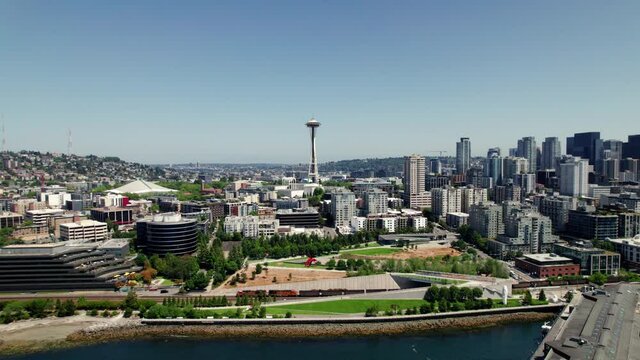 Drone Flying Sideways with Train Traveling Along Seattle Waterfront with Skyline in Background