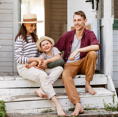 Happy family resting outside cottage