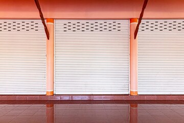 The silver roller shutter door of the store is closed