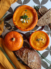 Squash filled with creamy pumpkin soup. Seasonal menu ideas. Vegan meal close up photo. Eating fresh concept. 
