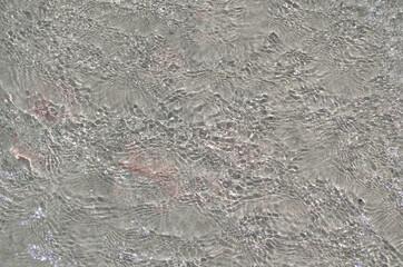 The surface of the sea with shallow ripples in shallow water as an abstract background.