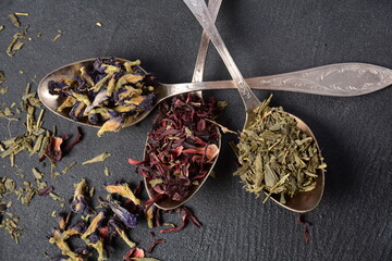 Various kinds of dry tea bancha green, Hibiscus, Butterfly Pea flower tea in spoons on the table