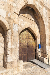 Fototapeta premium The entrance iron gate in the outer wall of the Tower of David - ancient citadel and city history museum near the Jaffa Gate in the old city of Jerusalem, Israel