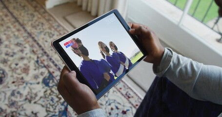 Composite of man sitting at home, watching baseball game during covid 19 on tablet - Powered by Adobe