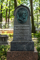 St. Petersburg. Russia. July 21, 2021 Necropolis at the Alexander Nevsky Lavra in St. Petersburg, Russia. Headstone and sculptures over the graves of famous people.
The inscription on the stone Evgeny