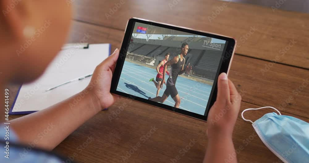 Canvas Prints Composite of woman on couch at home watching athletics running event on tablet