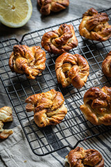 Cinnamon yeast knot buns on black cooling rack.