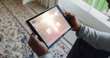 Composite of man sitting at home watching sports event on tablet