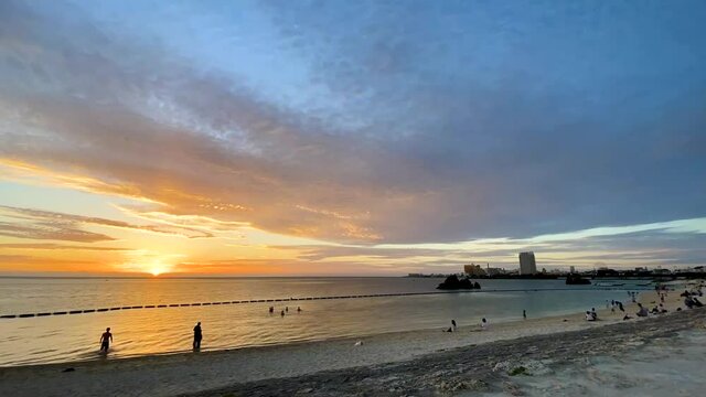 CHTAN-CHO, OKINAWA, JAPAN - JUNE 2021 : View of Araha beach (Ocean or sea) in sunset time. Wide view time lapse shot, dusk to night. Holiday, vacation and resort concept shot.