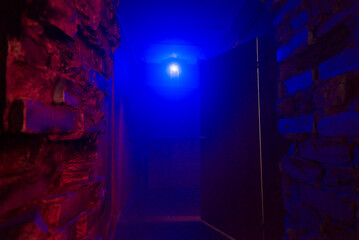 lamp in neon blue light in fog with red bricks