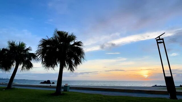 CHTAN-CHO, OKINAWA, JAPAN - JUNE 2021 : View of Araha beach (Ocean or sea) in sunset time. Wide view time lapse tracking shot, dusk to night. Holiday, vacation and resort concept shot.