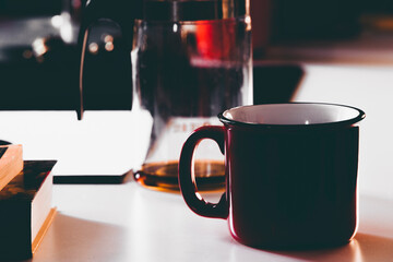 mug on the table against the background of books and teapot