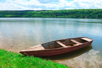 Wooden boat moored at the green shore