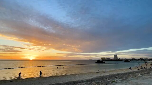 CHTAN-CHO, OKINAWA, JAPAN - JUNE 2021 : View of Araha beach (Ocean or sea) in sunset time. Wide view time lapse zoom out shot, dusk to night. Holiday, vacation and resort concept shot.
