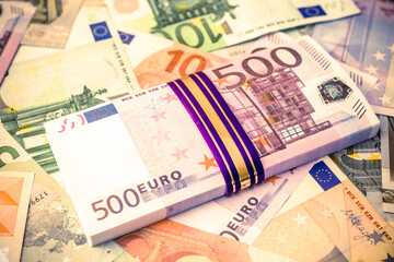 A pack of European currency lies on the background of the Euro
