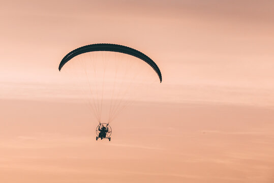 paragliding in the sky with a pilot at sunset