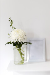 Large chrysanthemum in a glass vase. Photo frame with place for text,