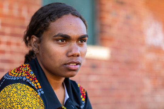 head and shoulders of young aboriginal woman with hair tied back