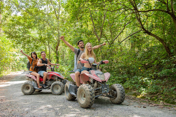 young couple or friend happy while riding an ATV in forest © Mrzproducer