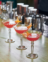 Cosmopolitan classic red cocktails in an elegant glass on the bar. High quality photo
