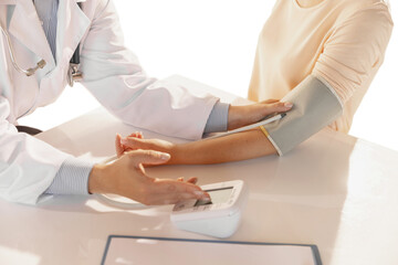 Close-up hands of doctor, therapeutic or medical advisor measuring pressure to patient, sick. Concept of healthcare, care and medicine.