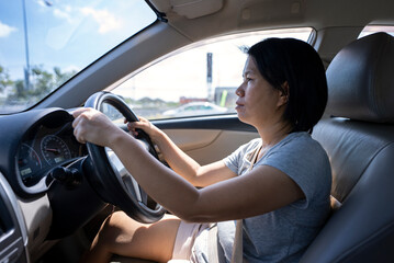 Female Asian driver fasten seatbelt and driving a car in highway for travel a vacation trip