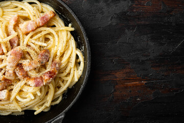 Carbonara pasta dish. Traditional Roman cuisine. Italian food, in cast iron frying pan, on old dark...