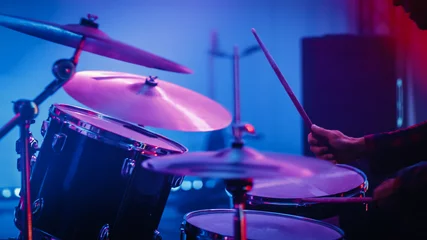 Fotobehang Rock Band Performing at a Concert in a Night Club. Close Up Portrait of a Drummer Playing the Drums. Live Music Party in Front of Bright Colorful Strobing Lights on Stage.  © Gorodenkoff