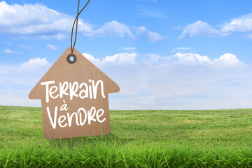 Terrain à vendre, affichage, signalisation sur fond herbe et ciel bleu