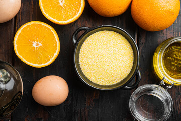 Orange polenta cake ingredients, with eggs and honey, on old dark  wooden table background, top view flat lay