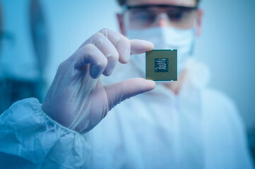 Engineer man  in sterile suit is holding Microchip with symbols in modern design factory  ,...