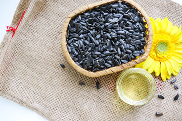 wicker basket with sunflower seeds, sunflower flower and a jar of sunflower oil