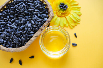 wicker basket with sunflower seeds, sunflower flower and a jar of sunflower oil