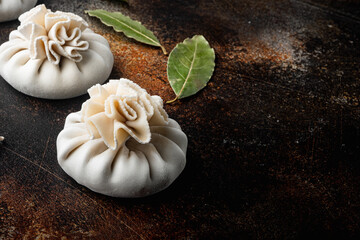 Fototapeta na wymiar Manti or manty dumplings, popular asian dish, on old dark rustic background, with copy space for text