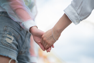 Close-up of two young women best friend holding hands. Friendship Relationship Concept.