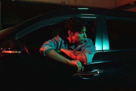 Latin man in car with color lights