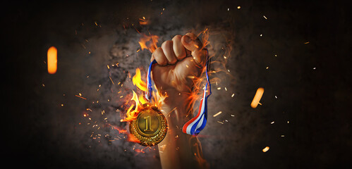 woman hand raised, holding gold medal in the fire. award and victory concept