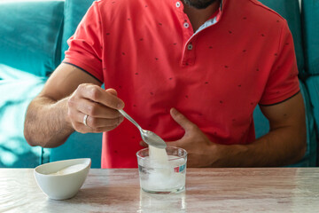Caucasian man with stomach ache preparing fruit salt