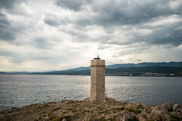 Fototapeta na wymiar Silo lighthouse in Punta Silo (šilo), Kvarner bay on Krk island, Croatia and the view of Crikvenica 