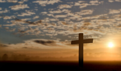 Silhouette of catholic cross at sunset background.