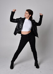 Full length portrait of young woman with natural brown hair,  wearing black leather scifi outfit...